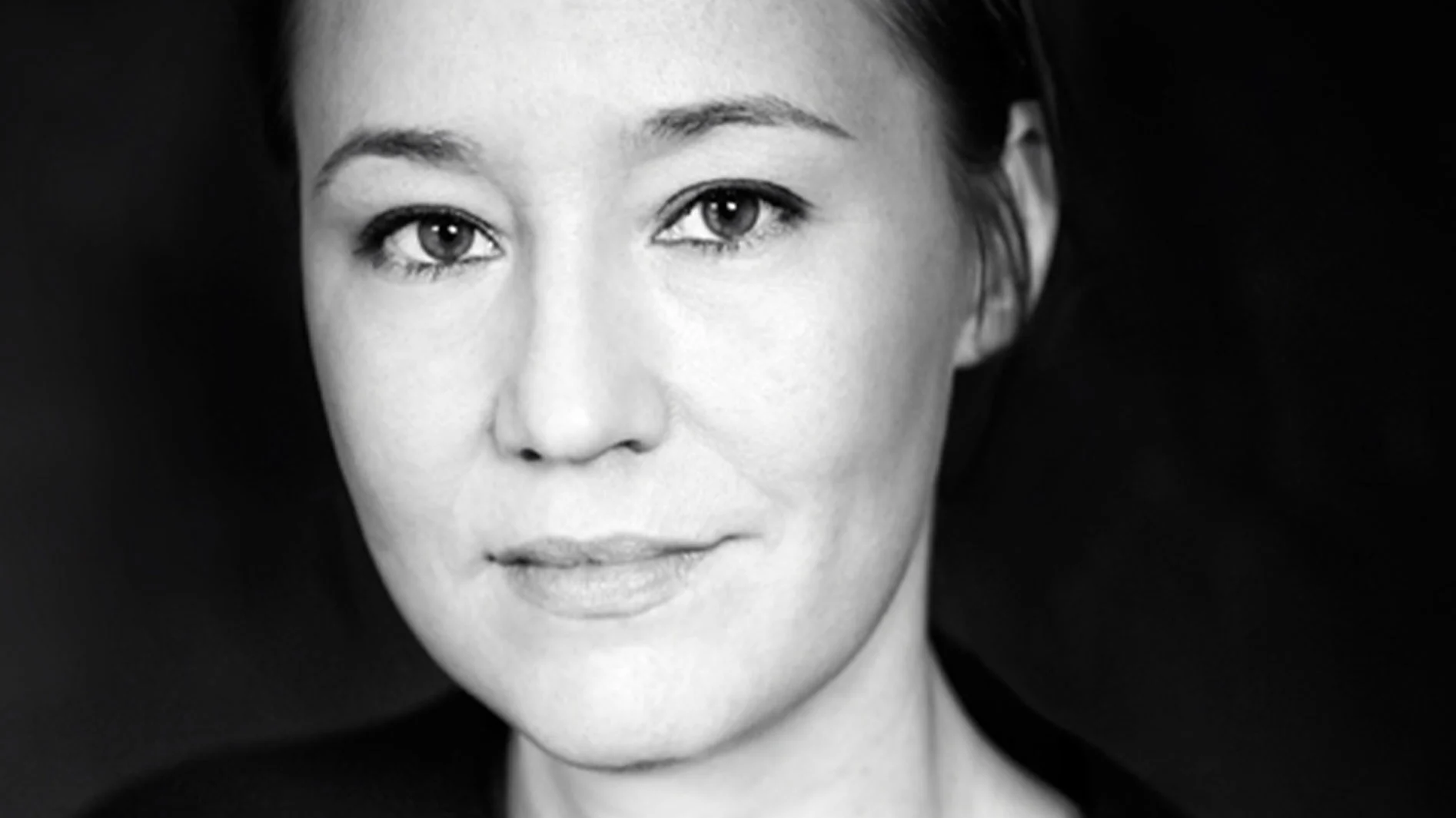 Svartvitt närbildsporträtt av en kvinna med mörka ögon och neutralt uttryck.