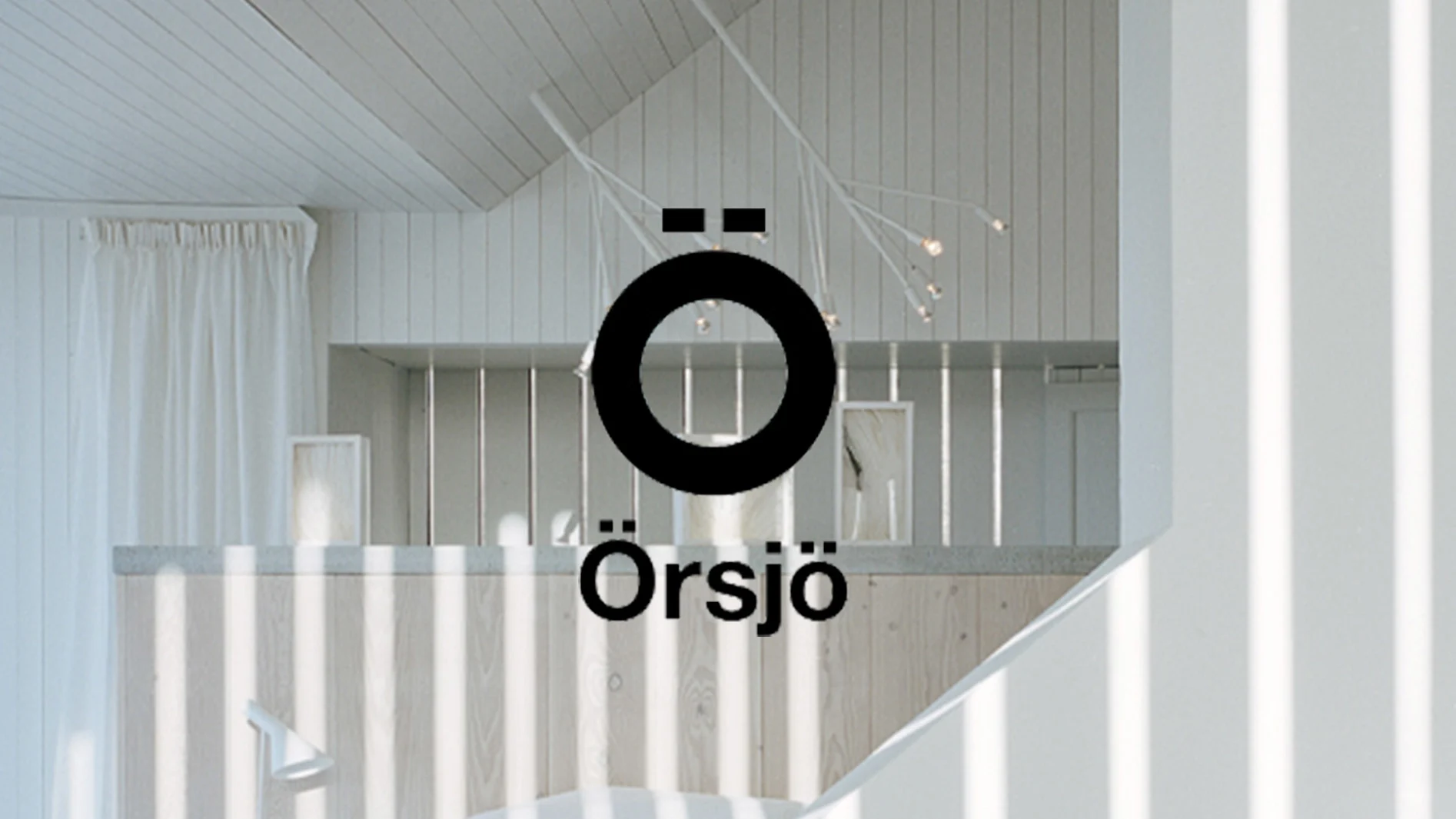 Örsjö-logotypen i svart över ett ljust, modernt rum med vita träpaneler och en grenliknande lampa.