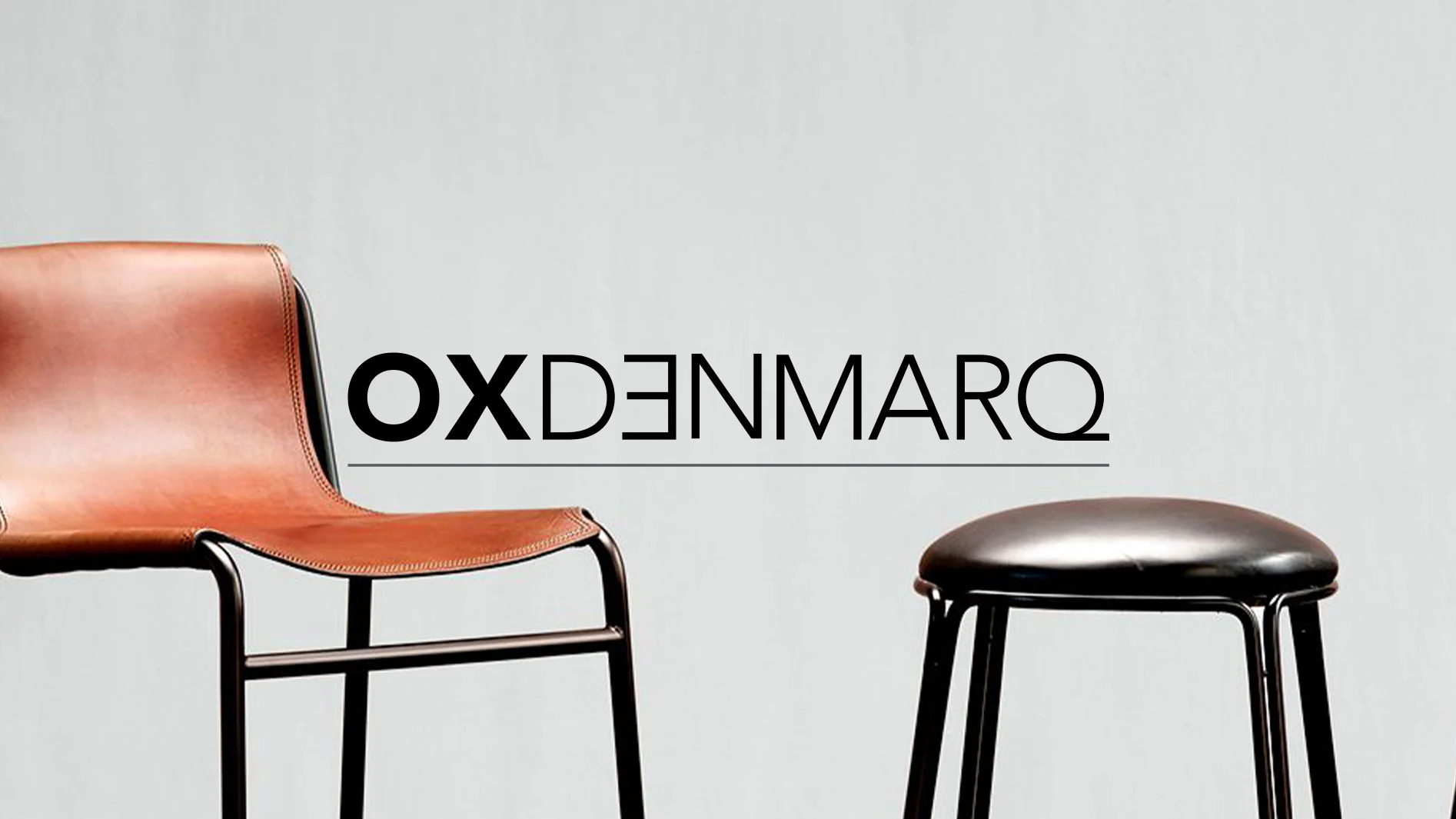 En brun läderstol och en svart läderpall med OXDENMARQ-logotyp.